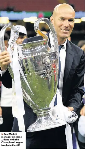  ??  ?? > Real Madrid manager Zinedine Zidane with the Champions League trophy in Cardiff