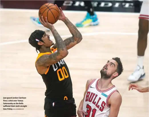  ?? RICK BOWMER/AP ?? Jazz guard Jordan Clarkson fires a shot over Tomas Satoransky as the Bulls suffered their sixth straight loss Friday.