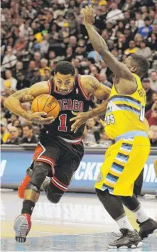  ?? | CHRIS SCHNEIDER/AP ?? Bulls point guard Derrick Rose drives against Nuggets point guard Nate Robinson on Thursday. Rose scored 19 points on 9-for-20 shooting.