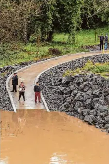  ?? Santiago Mejia/The Chronicle ?? Onlookers check out an obstructed path Thursday in Guernevill­e along the Russian River, which floods regularly.