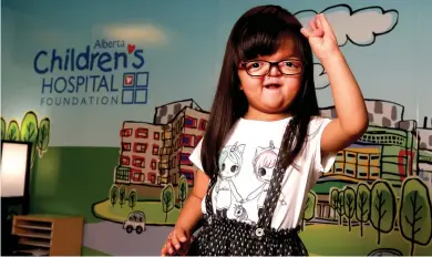  ?? CHRISTINA RYAN, POSTMEDIA CONTENT WORKS ?? Everly Tram, who has a rare genetic disorder called Apert Syndrome, holds up four fingers to show her age.