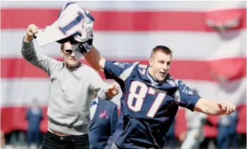  ??  ?? Rob Gronkowski le arrebata a Tom Brady el jersey recién recuperado en Fenway Park.