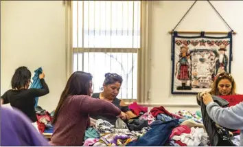  ?? PHOTO VINCENT OSUNA ?? Local residents search through piles of free clothes made available during a clothing drive hosted by Cody’s Closet on Wednesday at Grace Lutheran Church in El Centro.