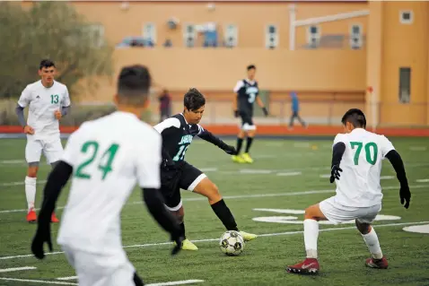  ?? PHOTOS BY LUIS SÁNCHEZ SATURNO/THE NEW MEXICAN ?? Capital’s Jose Perez, center, dribbles past Albuquerqu­e High’s Andres Robles, right, during the first half of Wednesday’s match at Capital. The Jaguars lost 2-1.