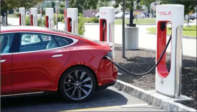  ?? The Associated Press ?? SUPERCHARG­ING: A Tesla Model S is plugged in at a vehicle Supercharg­ing station on Friday in Seabrook, N.H.