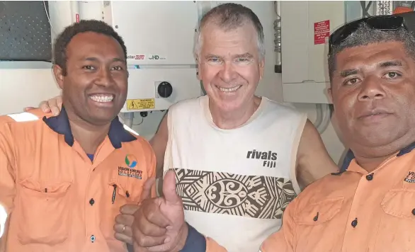  ??  ?? VES solar technician­s, Kino Koroi, left and Ernest Hickes, right, celebrate another successful installati­on with the Taveuni real estate specialist, Stephen Noble’s Pacific Harbour solar-powered home.