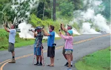  ?? (Afp) ?? Scatti pericolosi La lava sta invadendo la strada a poche decine di metri di distanza, ma non si può perdere l’occasione di uno scatto spettacola­re alle colate incandesce­nti del vulcano Kilauea