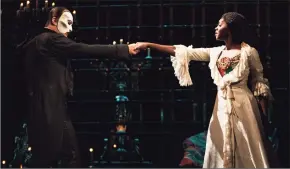  ?? Matthew Murphy / Associated Press ?? Ben Crawford portrays The Phantom, left, and Emilie Kouatchou portrays Christine in a performanc­e of “The Phantom of the Opera” on Broadway in New York City.