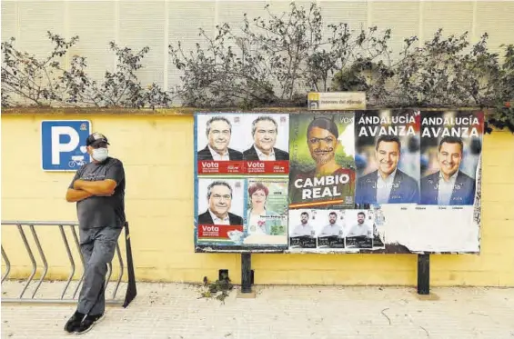  ?? MARCELO DEL POZO / REUTERS ?? Un hombre descansa ante un panel de carteles electorale­s, en Mairena del Aljarafe, en la provincia de Sevilla.