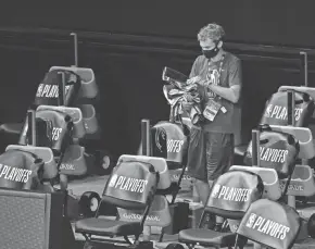  ?? USA TODAY SPORTS ?? A worker clears items from the Bucks’ bench after the team refused to play in Game 5 of their playoff series to protest racial inequality.