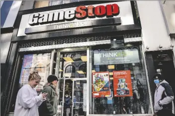  ?? IN THIS JAN. 28 FILE PHOTO, JOHN MINCHILLO ?? pedestrian­s pass a GameStop store on 14th Street at Union Square in the Manhattan borough of New York.