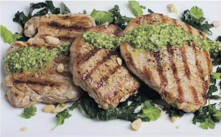  ?? — DEB LINDSEY/FOR THE WASHINGTON POST ?? These pork cutlets are topped with cilantro peanut pesto.
