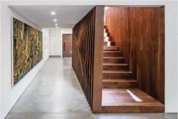  ??  ?? La scultorea scala di legno di noce introduce allo spazio principale della casa, un open space che comprende living (sopra), zona pranzo (sotto), studio e galleria (pagina accanto).