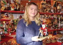  ?? BARB AGUIAR/Westside Weekly ?? Chanelle Hawes displays a Santa that has been a popular item at the Christmas market set up in the Gasthaus on the Lake’s courtyard on Beach Avenue in Peachland.