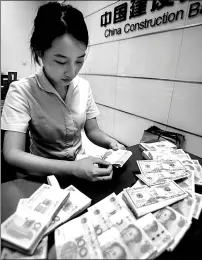  ?? XU JINBAI / FOR CHINA DAILY ?? A worker at the China Constructi­on Bank counts banknotes at a branch in Haian, Jiangsu province.