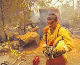  ?? JOHN LOCHER/ASSOCIATED PRESS ?? Shawn Slack rests Monday after felling trees burned in the Camp Fire in Paradise, California. President Donald Trump approved a major disaster declaratio­n for California on Monday.