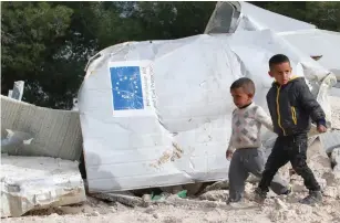  ?? (Abdelrahma­n Younis/Reuters) ?? PALESTINIA­N BOYS walk past the remains of their family’s dwelling after it was demolished by Israeli forces, near the West Bank village of Al-Eizariya.