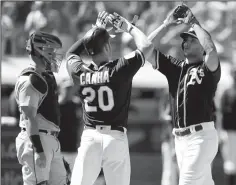  ?? NHAT V. MEYER/TRIBUNE NEWS SERVICE ?? The Athletics' Matt Olson (28) high-fives teammate Mark Canha (20) after Olson hit a two-run home run against the Detroit Tigers in the eighth inning on Sunday in Oakland.