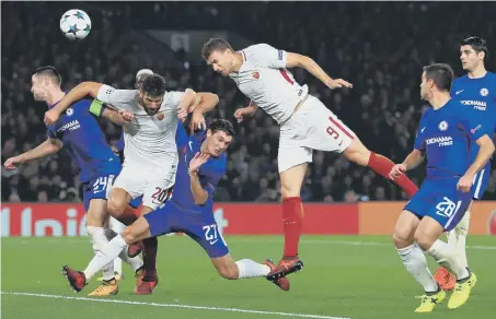  ??  ?? Edin Dzeko heads home Roma’s third goal in last night’s dramatic Champions League draw at Chelsea.