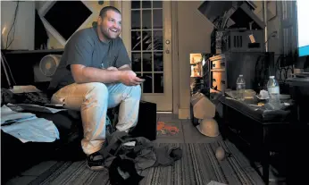  ?? WASHINGTON POST PHOTO BY MICHAEL S. WILLIAMSON ?? Luke Buckingham sits in the basement room he rents in his father’s Canton, Md., home. He is a thirdyear apprentice in the Ironworker­s Local 16 training program and hopes to make a living as a union man and buy a house.