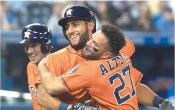  ?? - La Presse canadienne: Fred Thornhill ?? Abraham Toro reçoit l’accolade de son coéquipier Jose Altuve, dimanche, après avoir frappé un circuit en neuvième manche face aux Blue Jays, à Toronto.