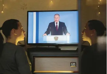  ?? GETTY-AFP ?? A woman watches a TV broadcast of Russian President Vladimir Putin’s address Tuesday in Simferopol, Crimea.