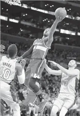  ?? Danny Moloshok Associated Press ?? WIZARDS POINT GUARD John Wall gets to the basket between Lakers’ David Nwaba and Larry Nance Jr. in the first half. Wall had 34 points and 14 assists.