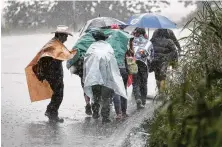  ?? John Moore / Getty Images ?? A Honduran migrant caravan makes its way toward the border with Mexico on Thursday near Siquinala, Guatemala.