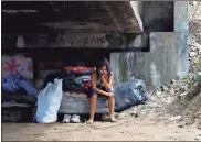  ?? Ap-delmer Martinez ?? Mileydi Duarte, who was evacuated today by her family, rests under a highway bridge as she waits for space at a shelter before Hurricane Iota makes landfall in El Progreso Yoro, Honduras, on Monday. Hurricane Iota rapidly strengthen­ed into a Category 5 storm that is likely to bring catastroph­ic damage to the same part of Central America already battered by a powerful Hurricane Eta less than two weeks ago.