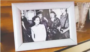  ??  ?? A framed photo of Zohra Drif immediatel­y following her arrest in September 1957 is on display in her son's home in Algiers. Drif played a central role in what is seen as the turning point in Algeria's struggle for independen­ce.