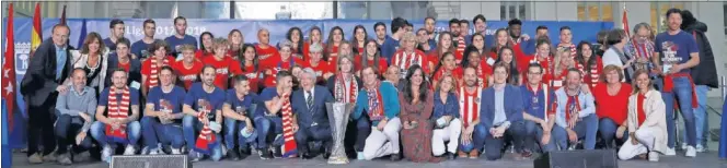  ??  ?? CAMPEONES Y CAMPEONAS. Las plantillas del Atlético posan con la alcaldesa de Madrid, Manuela Carmena, junto a la Europa League y las medallas de chocolate.