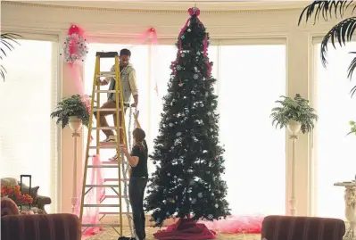  ?? Photos by Helen H. Richardson, The Denver Post ?? Xavier Bonney, left, gets help from his mother Trish as they decorate the Palm Room in the Governor’s Residence on Nov. 19.