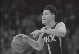  ?? The Associated Press ?? BRIGHT STAR: Phoenix Suns guard Devin Booker (1) gestures during the second half of the team’s NBA game Jan. 5 against the San Antonio Spurs in San Antonio. Booker, the high-scoring guard at the heart of Phoenix’s rebuilding plans, has signed a five-year, $158 million maximum contract with the Suns. Booker, 21, tweeted a photo of himself smiling as he signed the deal Saturday night, moments before the Suns announced the deal.