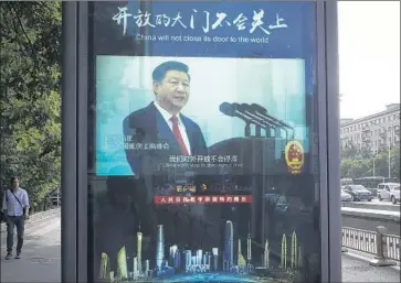  ?? Andy Wong Associated Press ?? THE ST. LOUIS FED warns that a trade war with China “could cause the United States to lose its global leadership in free trade and globalizat­ion.” Above, President Xi Jinping is shown on a street display in Beijing.