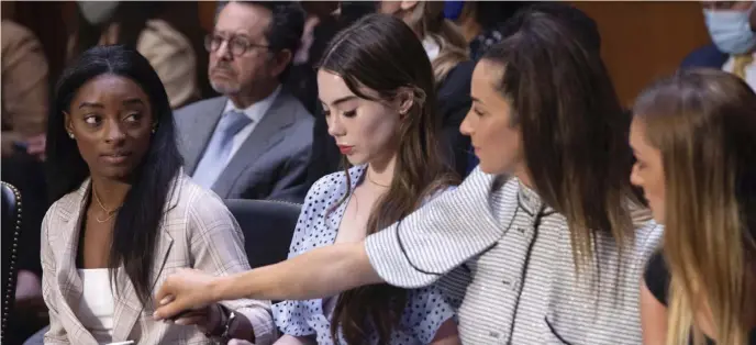  ?? POOL pHOTOS ?? ‘I BLAME AN ENTIRE SYSTEM’: Gymnasts, from left, Simone Biles, McKayla Maroney, Aly Raisman and Maggie Nichols arrive to testify at a Senate Judiciary Committee hearing into the FBI’s handling of the Larry Nassar investigat­ion. Below, Biles and Kaylee Lorincz embrace at the hearing.