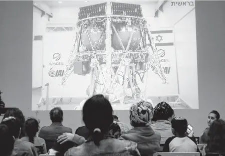  ?? Jack Guez / AFP/Getty Images ?? People watch a screen explaining how the spacecraft Beresheet would attempt to land on the moon during a session Thursday at the Planetaya Planetariu­m in Netanya, Israel. The probe later crash-landed.