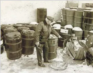  ?? OAK CREEK POLICE DEPARTMENT ?? A police investigat­or looks over the scene where Charles Duggan, 23, was killed in 1984 at Mid-America Steel Drum in Oak Creek. Duggan was capping a drum of chemical waste when incompatib­le chemicals in the drum reacted violently, triggering an...