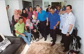  ?? BERNAMA PIC ?? Datuk Seri Najib Razak with Norhamimah Rahim (in wheelchair) and her husband, Isshamsul Ismail, after handing over keys to residents at PPR Tehel yesterday. With them are Malacca Chief Minister Datuk Seri Idris Haron (third from right).