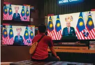  ?? Photo: AP ?? A man at an electronic­s shop listens as Ismail Sabri Yaakob announces the dissolutio­n of parliament in Kuala Lumpur yesterday.