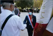  ??  ?? Pendant une commémorat­ion du souvenir, elle salue les porte-drapeaux