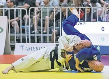  ?? Internatio­nal Judo Federation photo ?? Paul Bova of Trafford, left, throws his opponent during the Veteran World Judo Championsh­ips in Cancun. Bova, 61, earned the gold medal.Paul Bova of Trafford, right, poses with his coach Gary Goltz after winning his division at the Veteran World Judo Championsh­ips in Cancun.