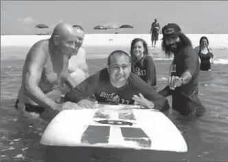  ?? COURTESY OF JAMES MULVANEY ?? Dan Mulvaney, who suffers from a rare form of autism, has found joy on a surfboard. Surroundin­g him, from left, are family friend Harvey Weisenberg, his father James Mulvaney and two surf instructor­s.