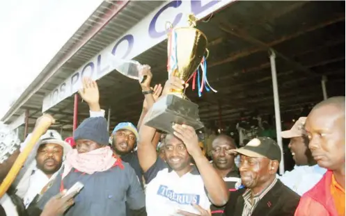  ?? Patron of Jos Malcomines polo team, winners of the Governor’s Cup, raises the trophy after presentati­on by the representa­tive of the Plateau State Governor and the Commission­er of Sports, Danladi Mang. Malcomines has won the Jos polo tournament a record f ??