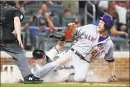  ?? Curtis Compton / Associated Press ?? Atlanta Braves catcher Brian McCann tags out the New York Mets’ Todd Frazier at the plate on a throw from Ronald Acuna Jr. during the sixth inning of Tuesday night’s game in Atlanta.