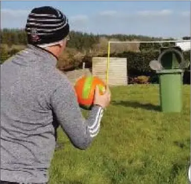  ??  ?? Sligo GAA coach Pat Kilcoyne said players can be imaginativ­e in ways to practice their skills. Here he is taking aim at ‘goalkeeper’ i.e. a wheelie bin in one of his videos in his back garden.