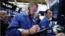  ?? RICHARD DREW — THE ASSOCIATED PRESS FILE ?? Trader Kevin Lodewick, center, works on the floor of the New York Stock Exchange.