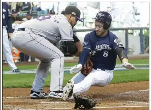  ?? AP/MORRY GASH ?? Milwaukee outfielder Ryan Braun (right) is tagged out at home plate by Colorado Rockies pitcher Antonio Senzatela on Thursday during the first inning of the Brewers’ 3-2, 10-inning victory in Game 1 of their National League division series at Miller Park in Milwaukee.