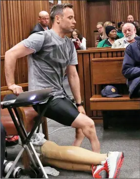  ??  ?? Exposed: Pistorius removes his prosthetic legs in court yesterday