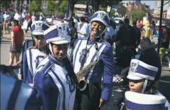  ??  ?? Saxophone player Sabria Davis, 17, center, of the North Side laughs Monday as she prepares to march with other members of the Barack Obama Academy marching band in the parade.