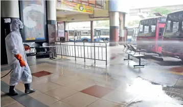  ?? — DEEPAK DESHPANDE ?? As the number of passengers walking through the Mahatma Gandhi Bus Station in Hyderabad increases, workers take precaution­s to sanitise the place on Friday.